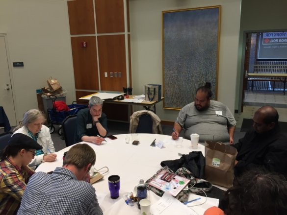 A group of 6 faculty is seated around a table, individually thinking about a mathematical task. 